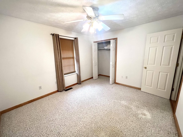 unfurnished bedroom featuring a textured ceiling, a closet, ceiling fan, and carpet floors