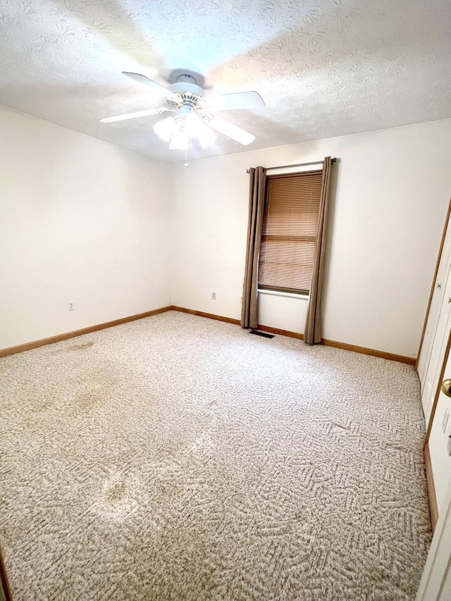 spare room with carpet flooring, a textured ceiling, and ceiling fan