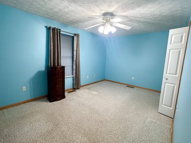 unfurnished bedroom with ceiling fan, light colored carpet, and a textured ceiling