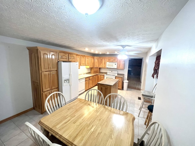 dining area with light tile patterned floors, a textured ceiling, ceiling fan, and sink