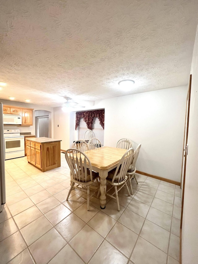 dining area featuring light tile patterned floors and a textured ceiling