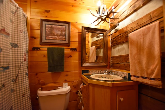 bathroom with wooden walls, oversized vanity, and an inviting chandelier