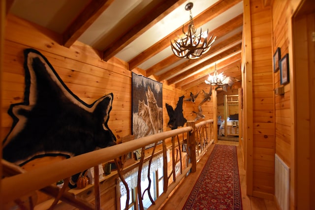 corridor featuring vaulted ceiling with beams, wood walls, a chandelier, and hardwood / wood-style flooring