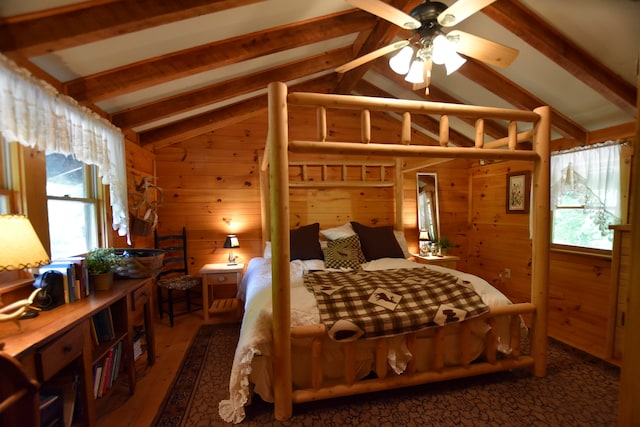 bedroom with wooden walls, dark wood-type flooring, ceiling fan, and vaulted ceiling with beams