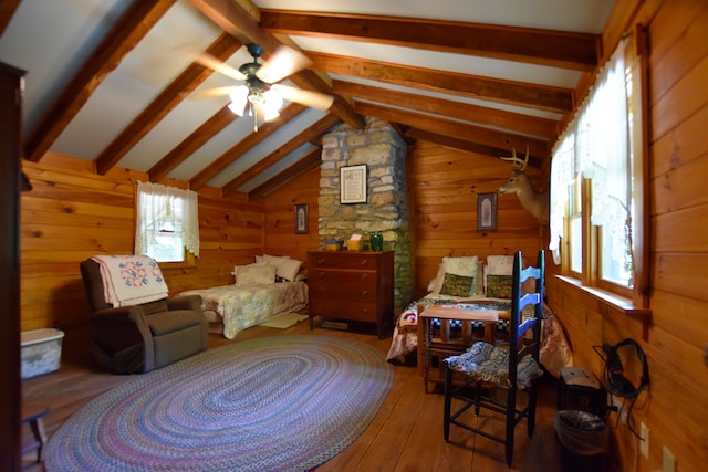 bedroom featuring lofted ceiling with beams, wooden walls, dark wood-type flooring, and multiple windows