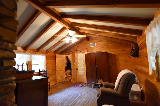 interior space featuring light hardwood / wood-style flooring, wooden walls, vaulted ceiling with beams, and ceiling fan