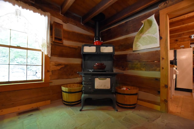 living room with a wood stove and wood walls