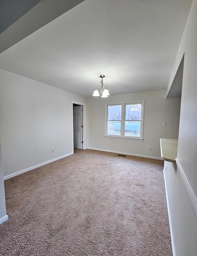 unfurnished room featuring light carpet and a chandelier