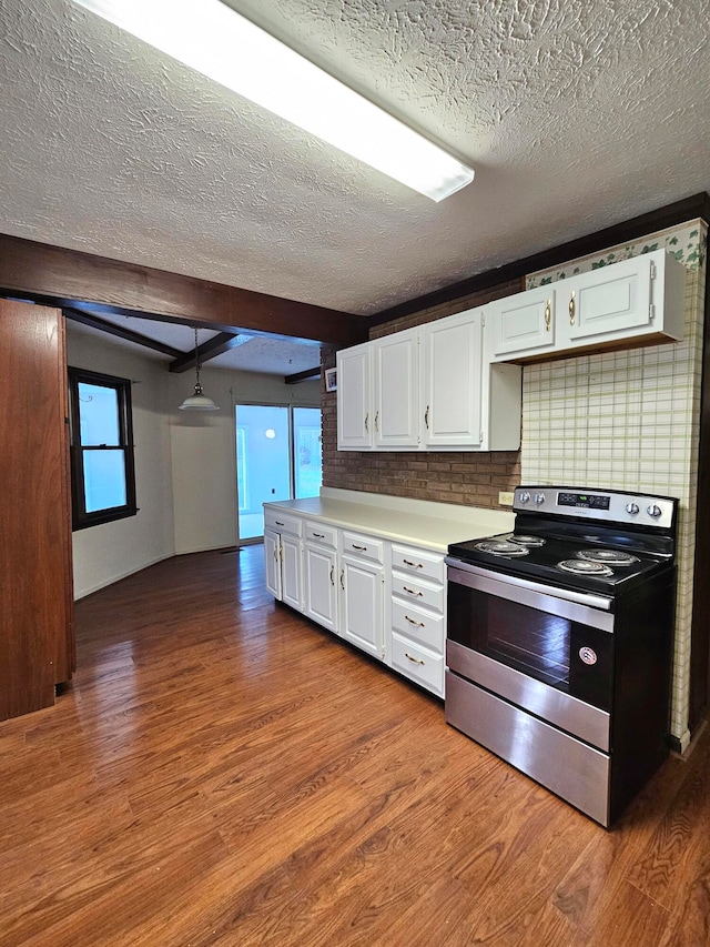 kitchen with stainless steel electric range, dark hardwood / wood-style flooring, beamed ceiling, a textured ceiling, and white cabinetry