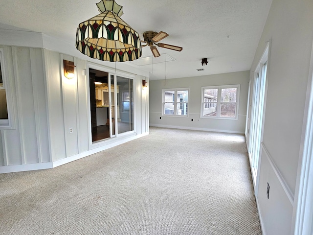 spare room featuring a textured ceiling, light colored carpet, and ceiling fan