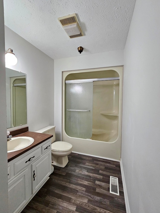 full bathroom featuring toilet, bathing tub / shower combination, a textured ceiling, vanity, and hardwood / wood-style flooring