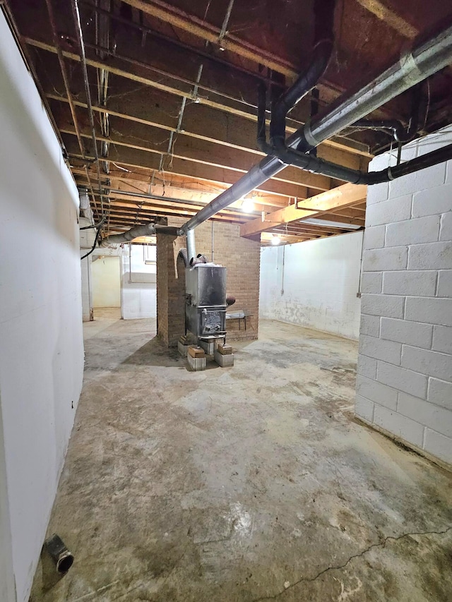 basement featuring heating utilities and a wood stove