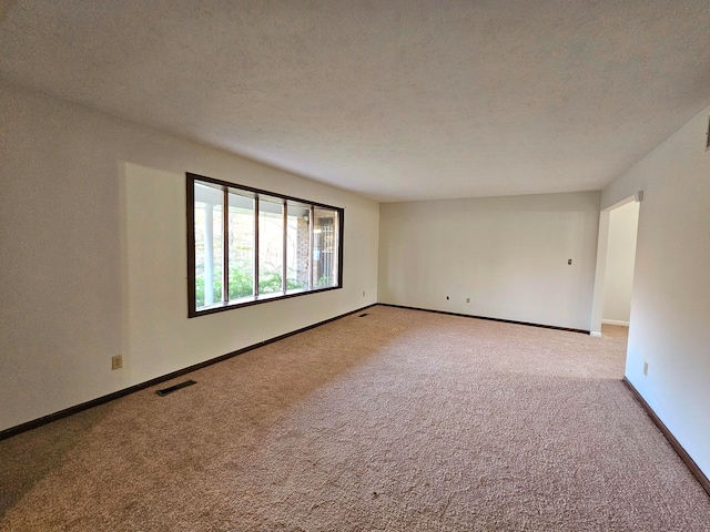 unfurnished room with light carpet and a textured ceiling