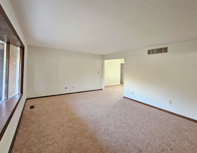 carpeted spare room featuring a textured ceiling