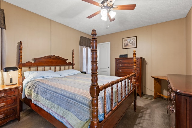 bedroom with a textured ceiling, dark carpet, and ceiling fan