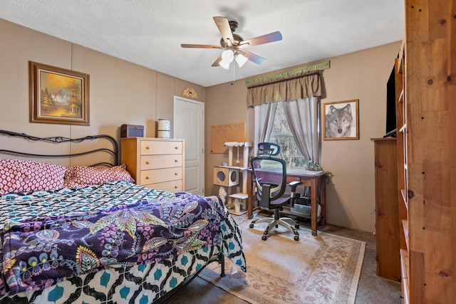 bedroom with a textured ceiling, carpet, and ceiling fan