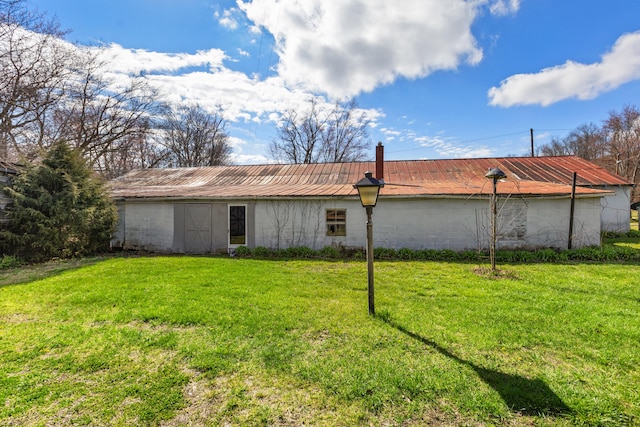 rear view of property featuring a lawn