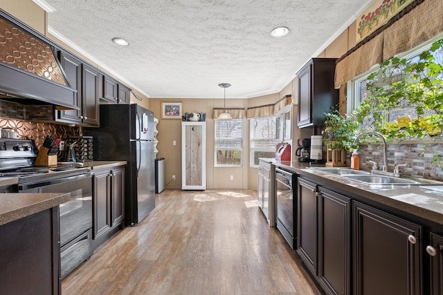 kitchen with backsplash, light hardwood / wood-style flooring, pendant lighting, and stainless steel stove