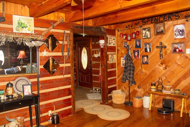 dining room with beam ceiling, wooden walls, and wood-type flooring