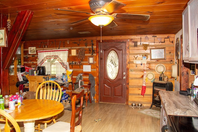 dining area with ceiling fan, wood walls, light hardwood / wood-style flooring, and wooden ceiling