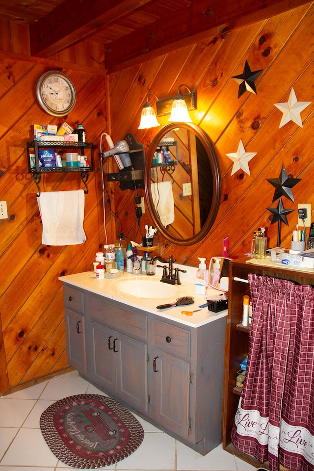 bathroom featuring tile patterned floors, wood walls, beamed ceiling, and vanity