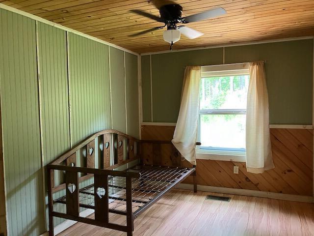 interior space featuring ceiling fan, light hardwood / wood-style floors, and wood ceiling