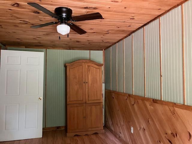 additional living space featuring wood ceiling, ceiling fan, and wood-type flooring