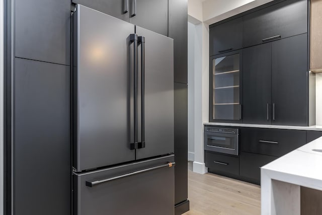 2420 Flying Ebony Dr, Lexington, KY 40509 - kitchen featuring light countertops, dark cabinetry, high end refrigerator, light wood-style flooring, and modern cabinets