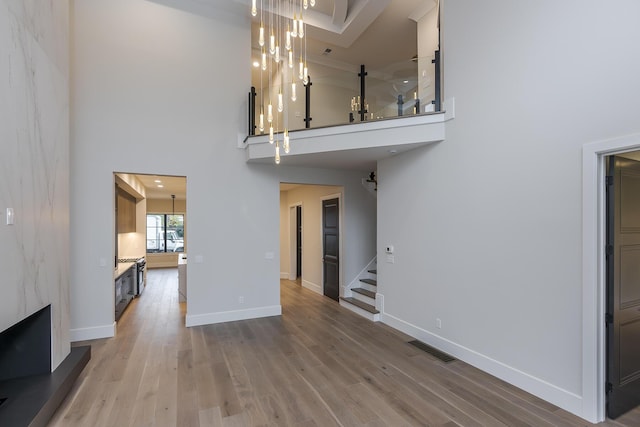 2420 Flying Ebony Dr, Lexington, KY 40509 - unfurnished living room with a high ceiling, wood finished floors, stairway, and visible vents