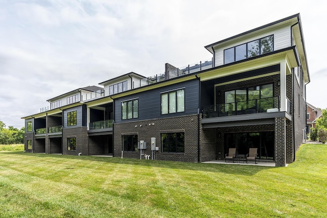2420 Flying Ebony Dr, Lexington, KY 40509 - back of house featuring a balcony, a lawn, a patio area, and brick siding