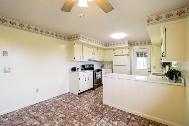 kitchen featuring under cabinet range hood, a peninsula, stainless steel range with electric cooktop, light countertops, and freestanding refrigerator