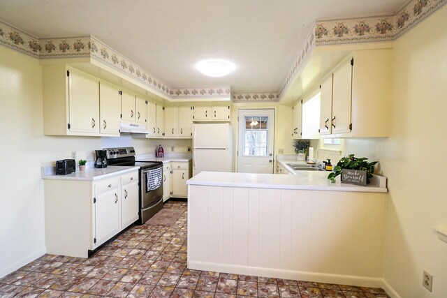 kitchen featuring freestanding refrigerator, a peninsula, under cabinet range hood, light countertops, and stainless steel range with electric stovetop