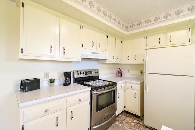 kitchen with a textured ceiling, under cabinet range hood, light countertops, freestanding refrigerator, and stainless steel electric stove