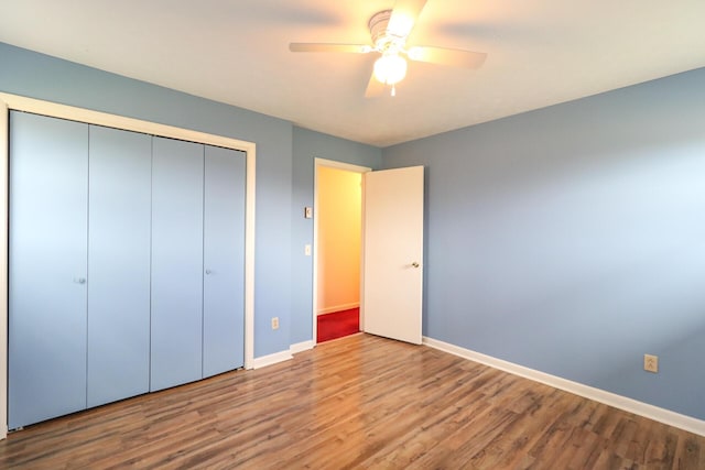 unfurnished bedroom with a closet, ceiling fan, baseboards, and wood finished floors