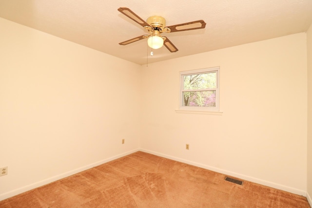 unfurnished room with baseboards, visible vents, light colored carpet, ceiling fan, and a textured ceiling