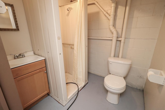 full bathroom with concrete block wall, finished concrete flooring, a shower with shower curtain, toilet, and vanity