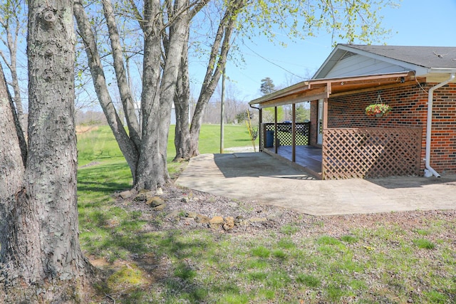 view of yard featuring a carport and concrete driveway