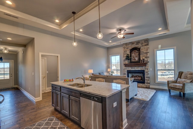 kitchen featuring dark hardwood / wood-style flooring, stainless steel dishwasher, ceiling fan, hanging light fixtures, and a raised ceiling