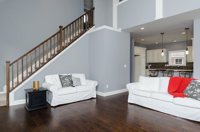 living room featuring a high ceiling and dark wood-type flooring