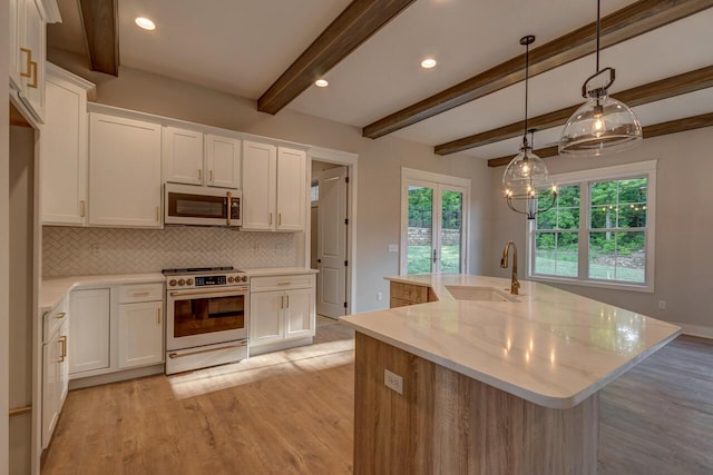 kitchen with a center island with sink, sink, white cabinetry, white range, and light stone countertops