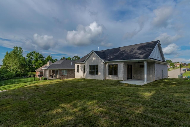 rear view of property featuring a lawn and a patio area