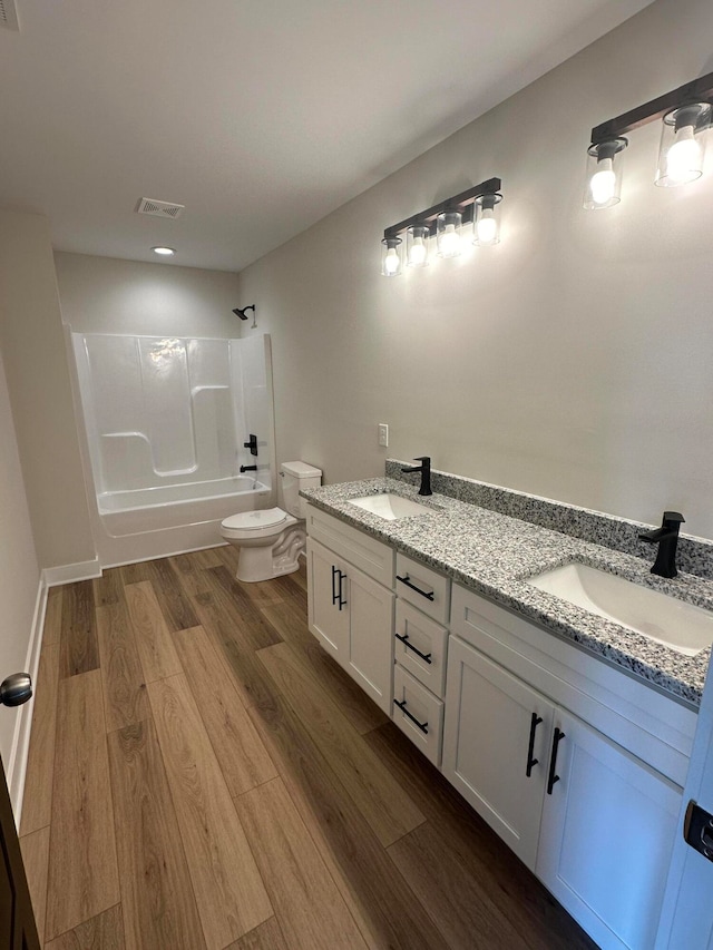 full bathroom featuring toilet, vanity, shower / bath combination, and hardwood / wood-style flooring