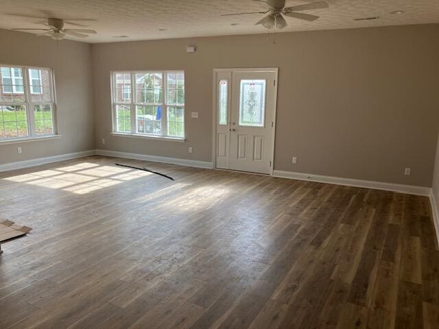 interior space with a textured ceiling, dark hardwood / wood-style floors, and ceiling fan