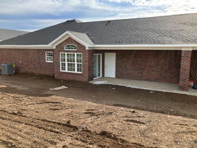 back of property with a patio and central AC