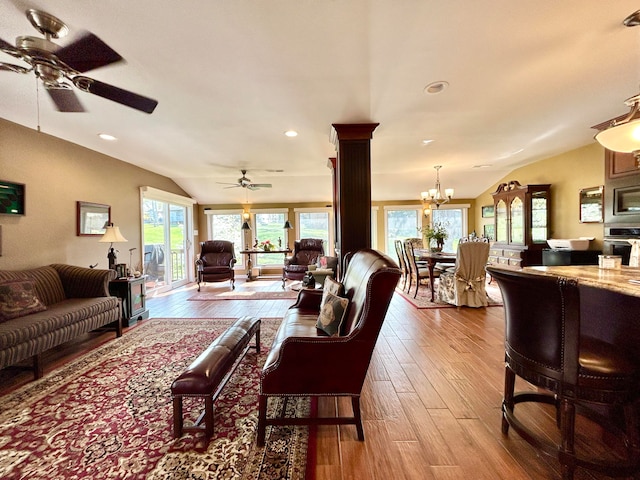 living room featuring ceiling fan with notable chandelier, light hardwood / wood-style flooring, and lofted ceiling