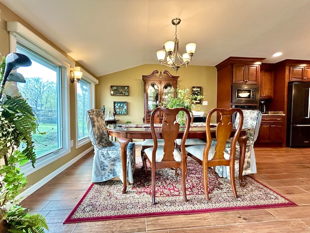 dining space featuring lofted ceiling, light wood-type flooring, and a chandelier