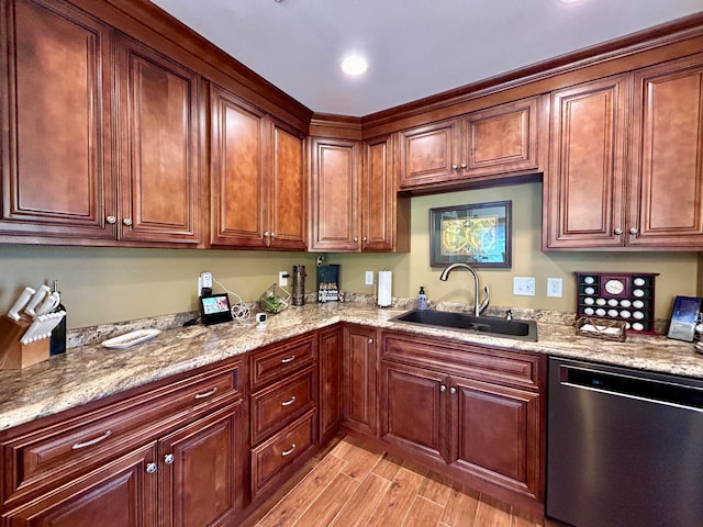 kitchen with stainless steel dishwasher, sink, light hardwood / wood-style flooring, and light stone counters