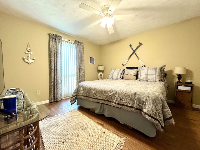 bedroom featuring ceiling fan, dark wood-type flooring, and a textured ceiling