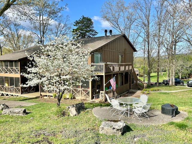 rear view of property with an outdoor fire pit, a lawn, and a patio area