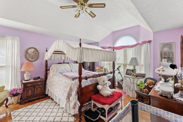 bedroom featuring a textured ceiling, ceiling fan, lofted ceiling, and light wood-type flooring